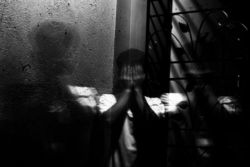 Man holding hands up to face