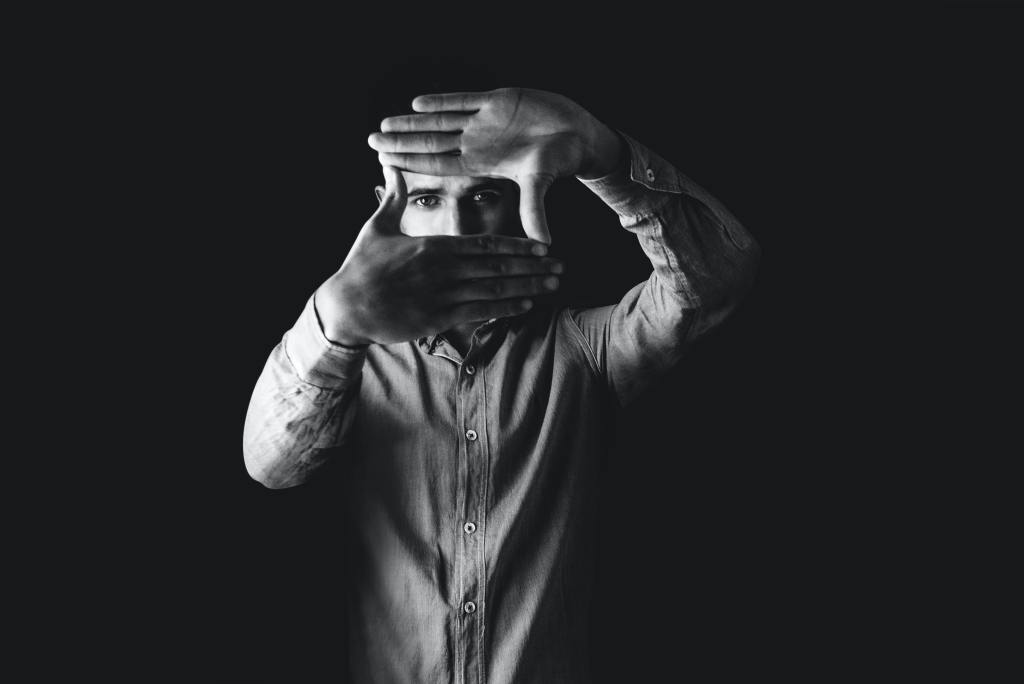 photo of a man holding up both his hands to create a box around his eyes