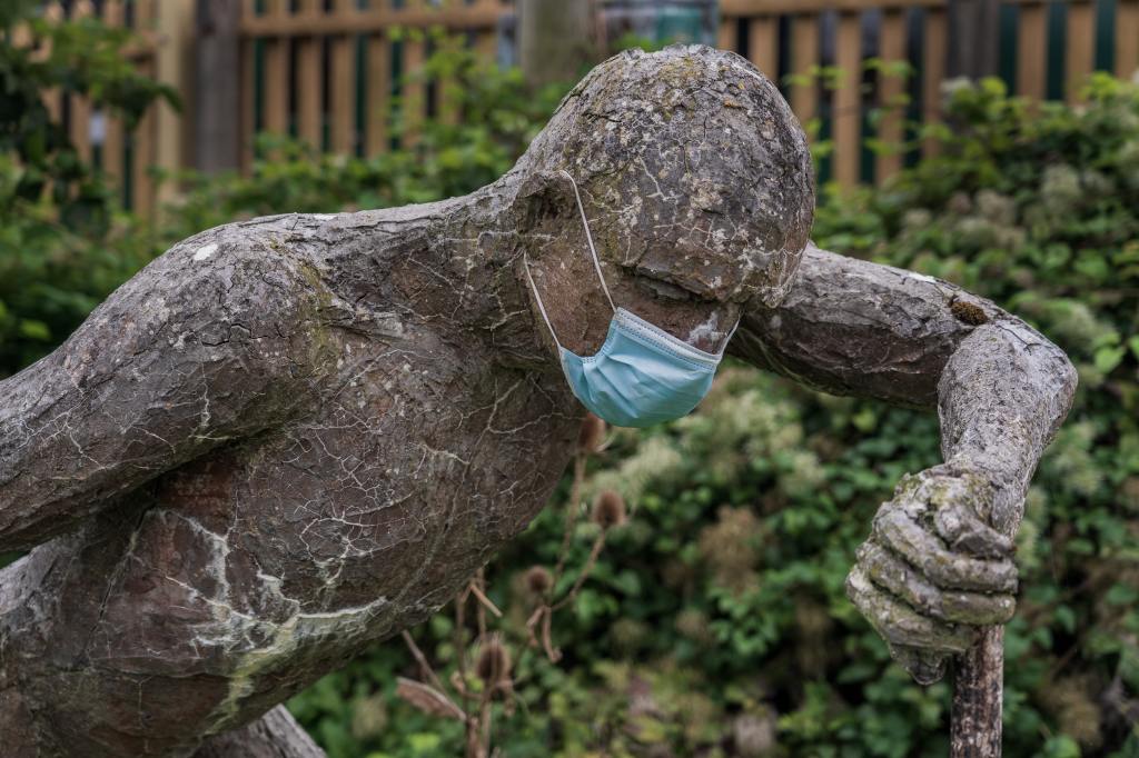 a masked sculpture of a man leaning down