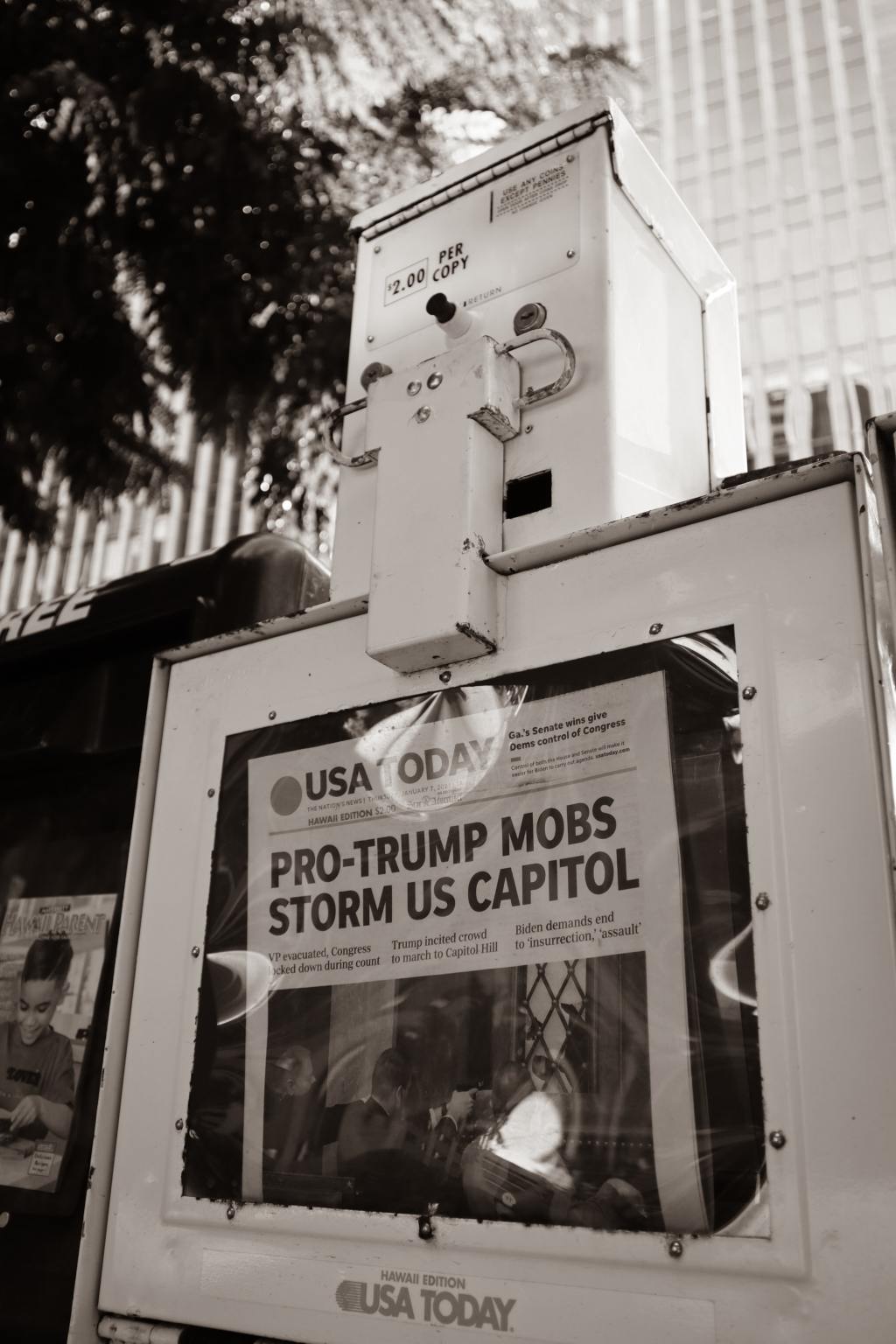 Black and white photo of Newspaper box with USA Today headlines