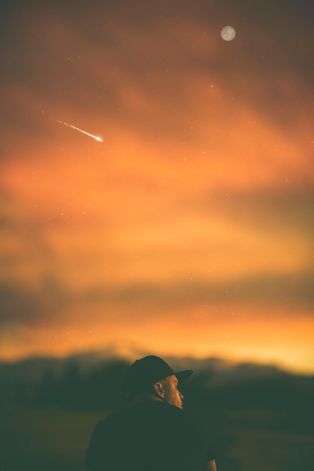 man, moon, meteor at dusk