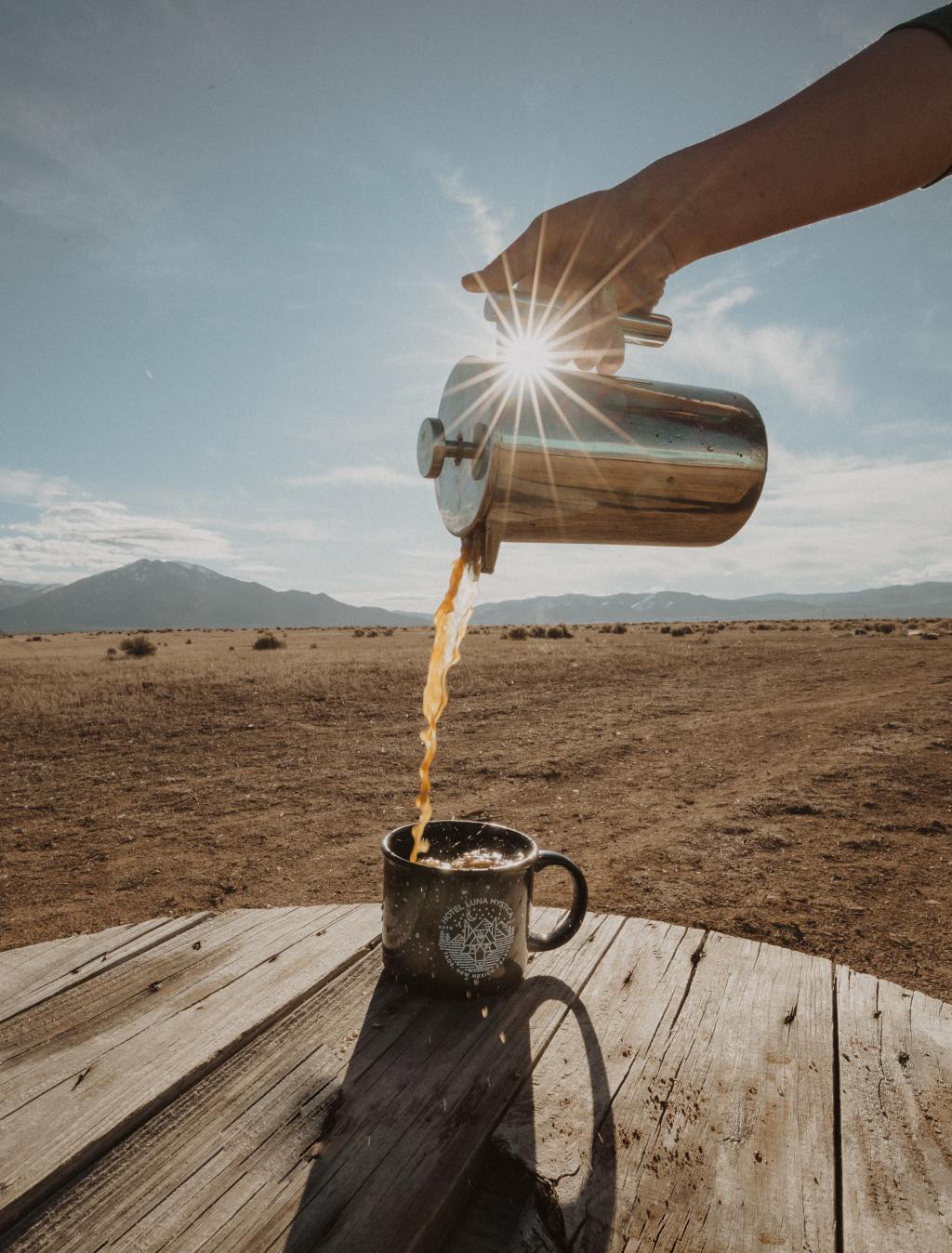 photo of landscape with hot coffee pouring into coffee cup