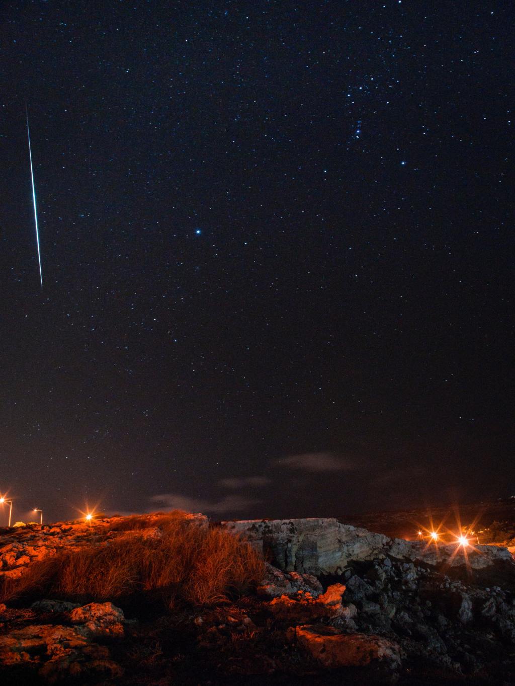 Night sky with stars and a streak of white in sky