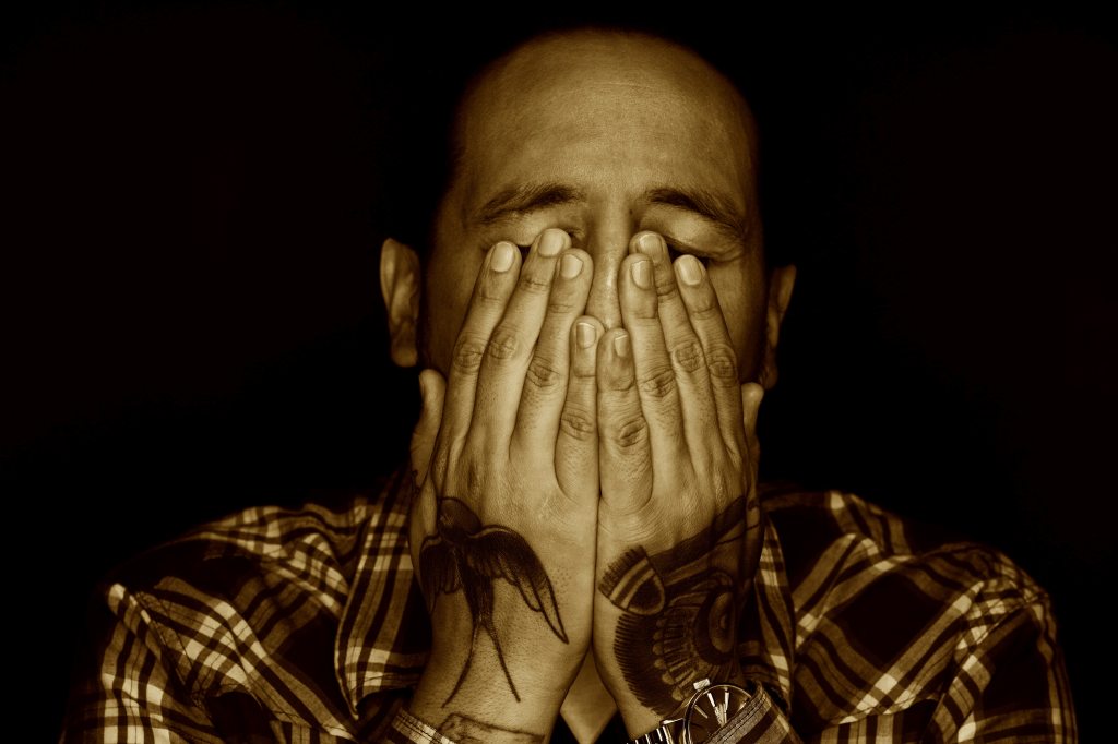 Man holding his face