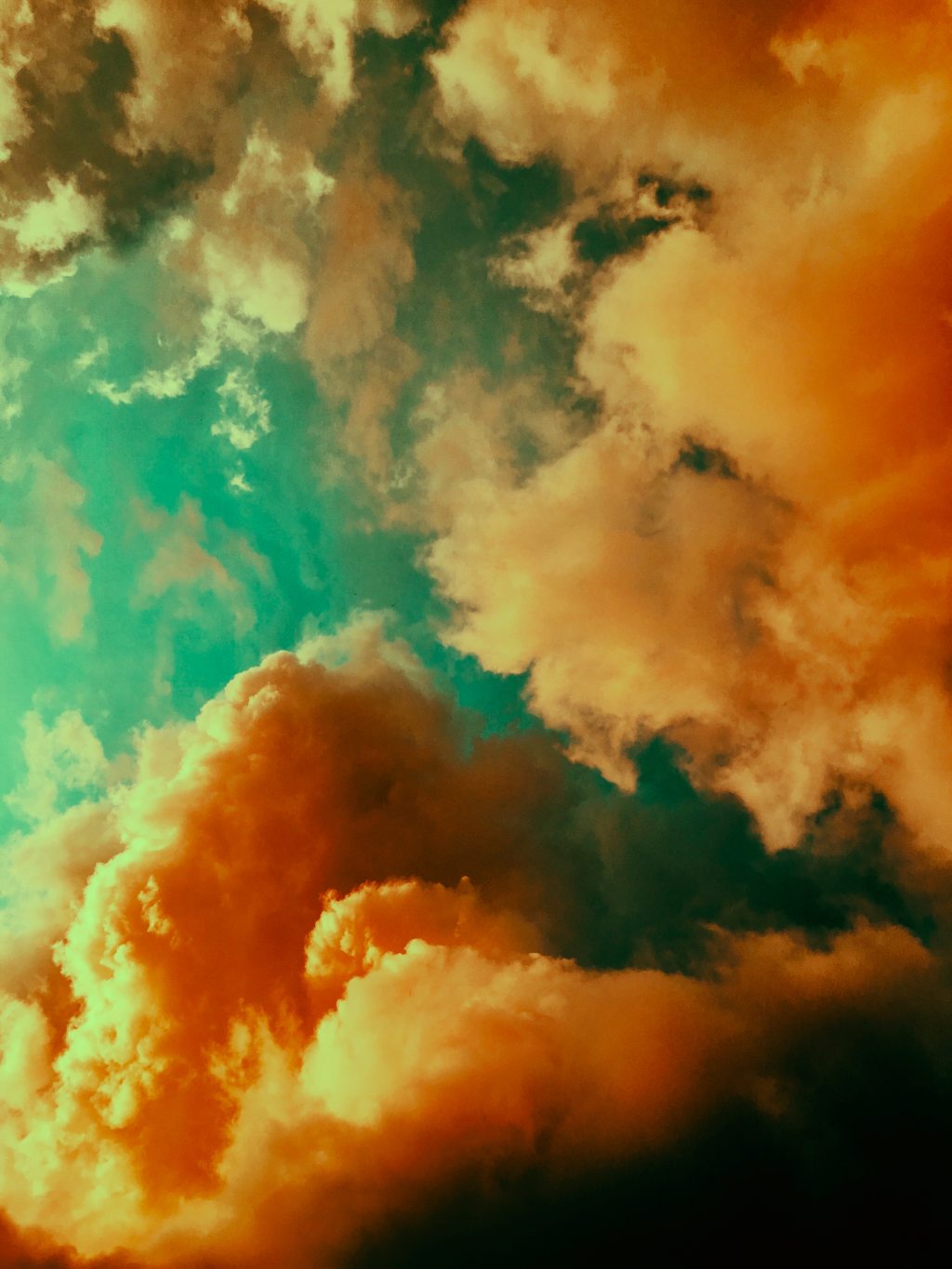 Photo of orange clouds against a turquoise sky