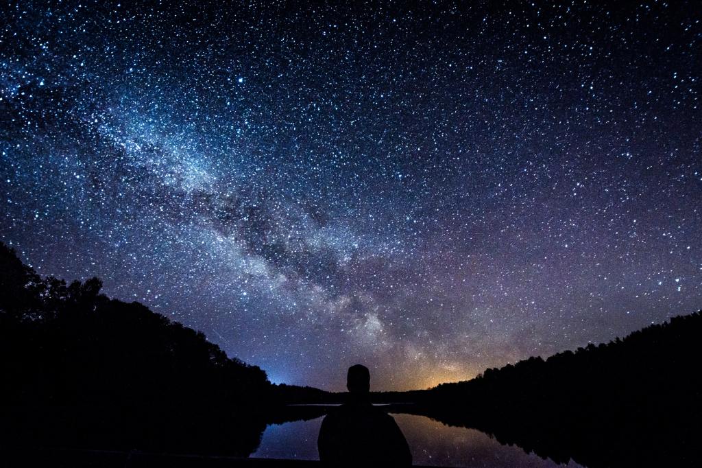 man looking at stars in the night sky