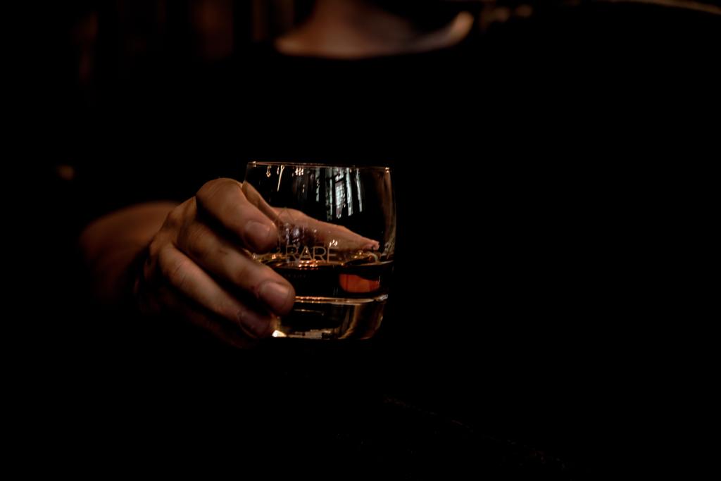 man holding whiskey glass