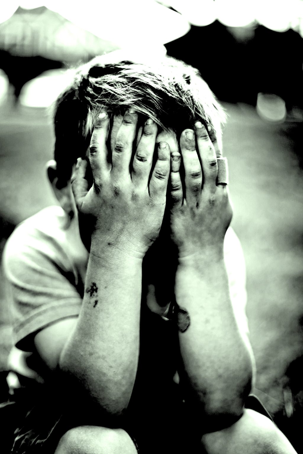 small child with hands covering their face